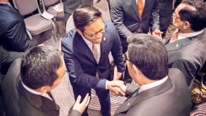 Looking down from above as a young man meets the Executive Minister and shakes his hand.